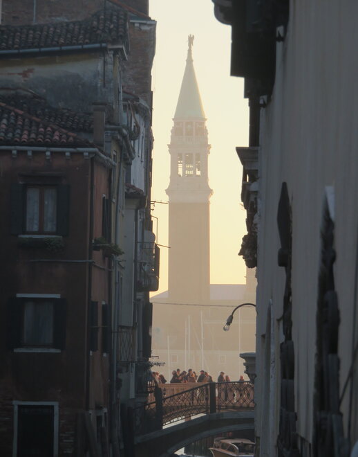 Bell tower behind the Bridge of Sighs between two apartments in late-afternoon Venice.