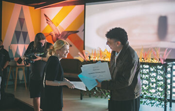 Juno presents a student from the Digital Creativity Foundation programme a Top Achiever award